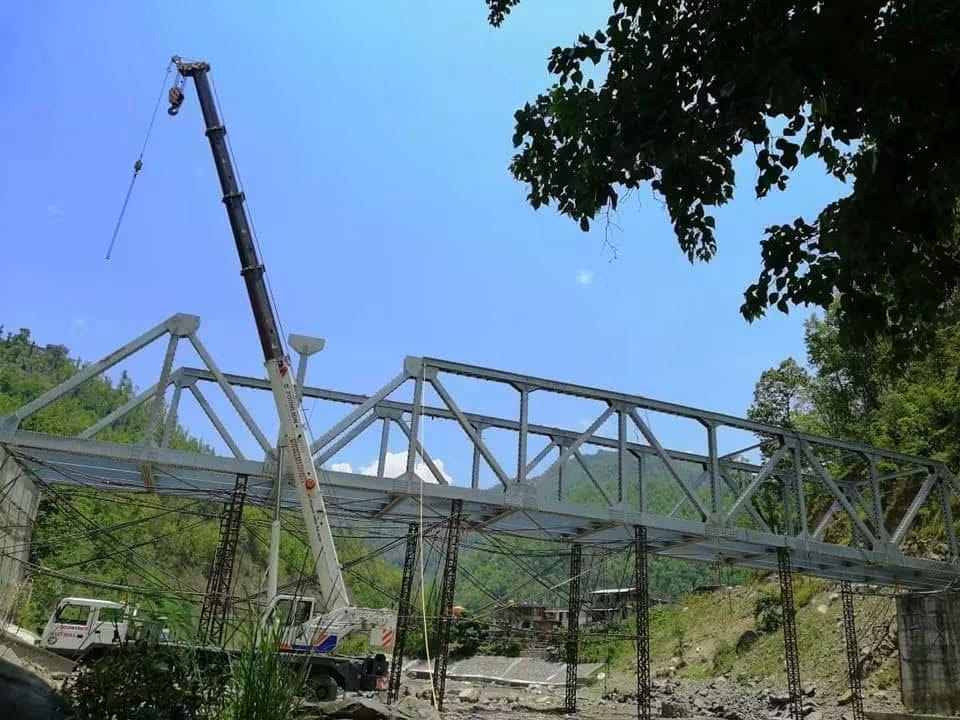 Steel truss bridge erection using a crane